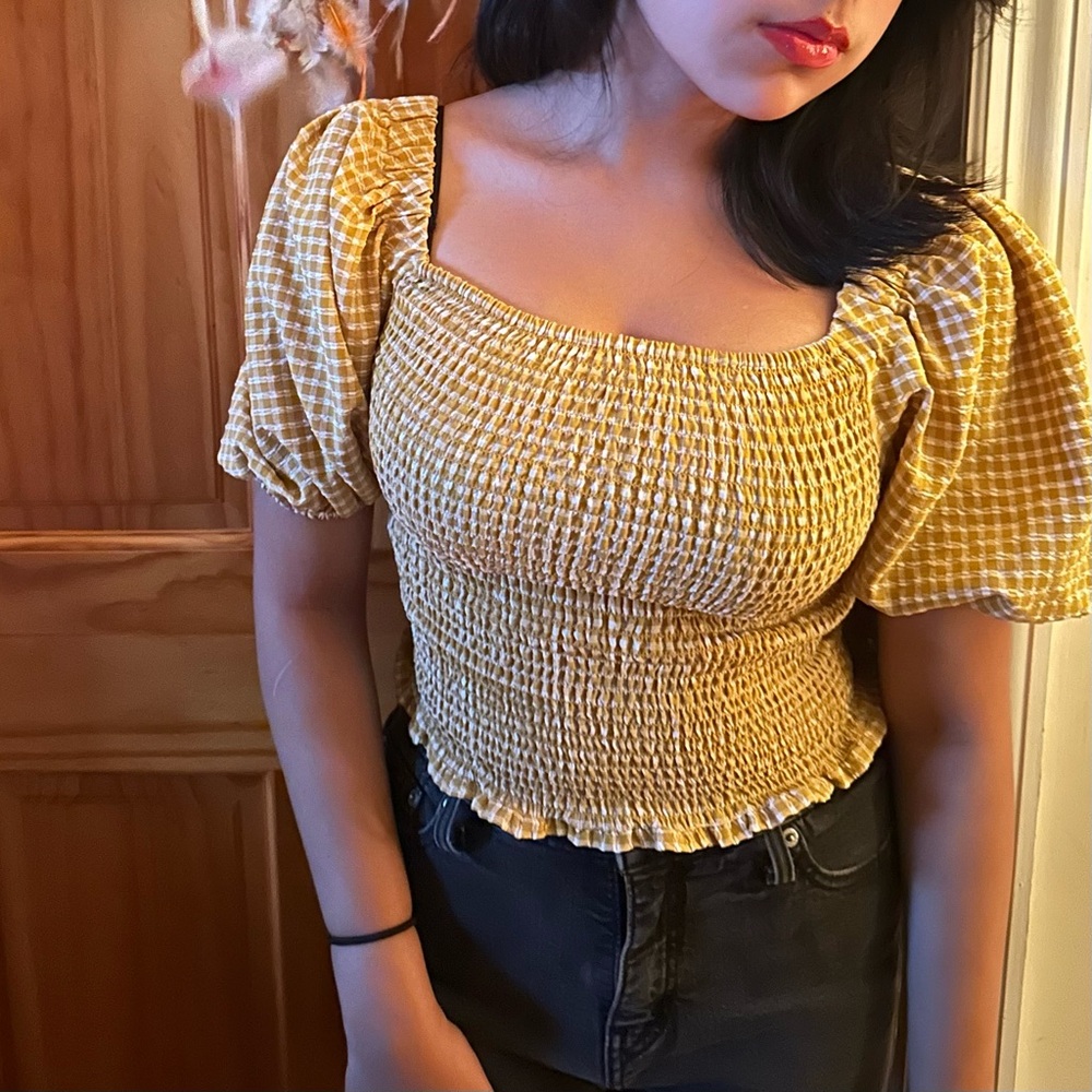 Smocked yellow top with mid length puff sleeves.